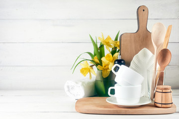 Kitchen wide banner concept. Kitchen background for mockup with spoon, teapot, cups, bowls, flowers on wooden table .