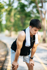 Fototapeta premium Men stand and bow and rest after exercising on the roadside.