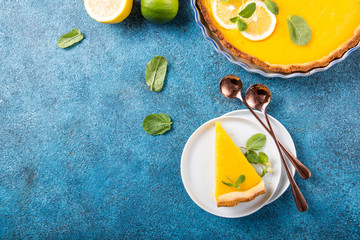 Food concept Homemade organic Lemon, lime tarts or cake  pie on blue stone board