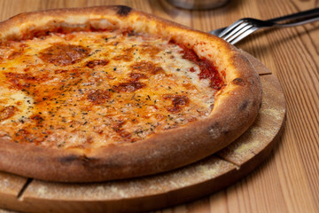 tomato-based cheese pizza. hearty italian pizza on a wooden board.