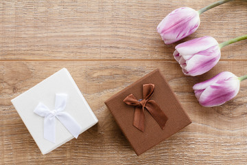 Gift boxes with tulips on wooden boards.