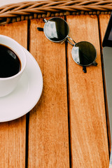 top view of the workspace with a laptop, on a brown wooden table with a cup of coffee. Copy space, wood background