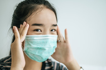 A woman wearing a striped shirt wearing a mask.