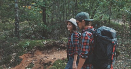 young man and woman hiking in forest
