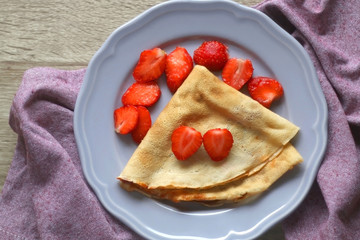 Homemade crepe with marmalade and sliced strawberries. Top view.