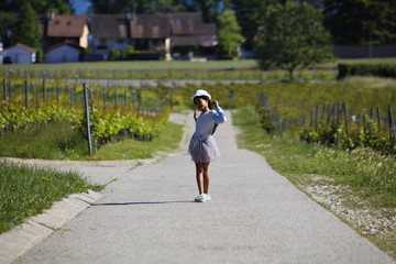 Fototapeta premium A cute young asian girl poses in a vineyard path