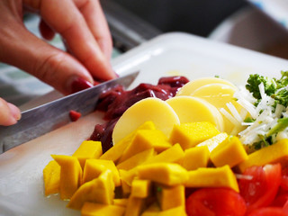 Closeup of hands of chef cook cutting vegetables