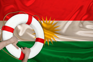 male hands hold on a white lifebuoy against the background of the silk national flag of the country...