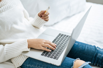 Woman playing laptop and hold a credit card.