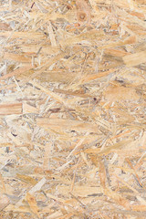 OSB panel texture. Oriented Strand Board. Chipboard building material. OSB wooden panel made of pressed sandy brown wood shavings as background