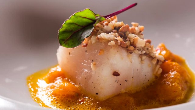 Roasted cod, codfish with baked pumpkin. Front view with smoke