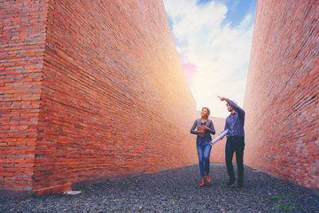 Structural engineer and architect working with blueprints discuss at the tall wall building...