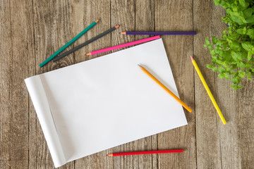 Sketchbook and pencils on an old wooden table. Template for text.