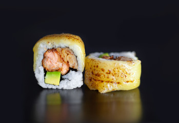 Sushi roll with fried salmon, avocado and melted cheese