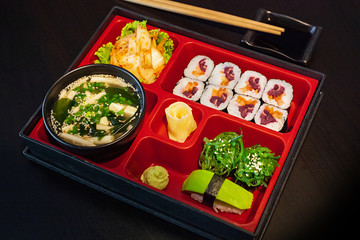 Vegan sushi bento lunch with miso soup, vegetable maki, avocado and seaweed gunkan