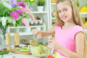 Obraz na płótnie Canvas Portrait of cute girl preparing delicious fresh salad