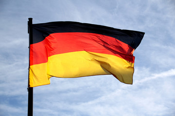 flag of the federal republic of Germany freely flutters in the wind against a blue sky, , concept of tourism, economy, politics, emigration, business