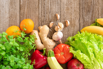 Vegetable and fruit assortment: apples, bananas,tomatoes,zucchini,sweet peppers, orange, garlic and lettuce. Template for text, top view.