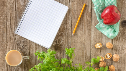 Notepad, pencil, Cup of coffee, Apple and walnuts on napkins. Template for text, top view.