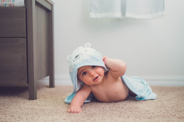 6 month old wrapped in a bath towel doing tummy time 