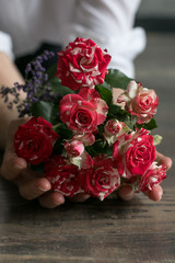 Original bouquet at the floor. Wooden floor with flowers. Present at the anniversary. Printing for postcard. Image with selective focus.