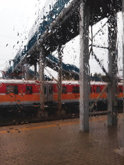 View on railway train through rainy window.