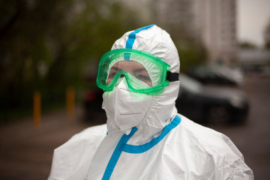 A doctor in a protective suit, glasses and a mask.