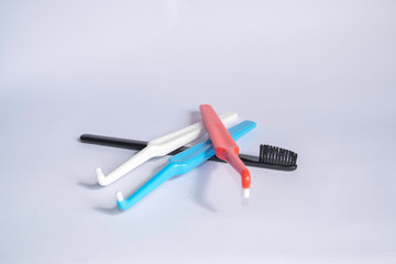 Four multi-colored different toothbrushes on a white background. Colored toothbrushes for implants and braces