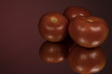 Tomato on red reflective studio background. Isolated red shiny mirror background for every concept.