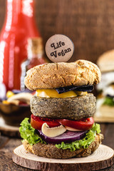 vegan snack, meatless hamburger, with small plate written in English Vegan life. Gluten-free meal, made with different vegetables and proteins.