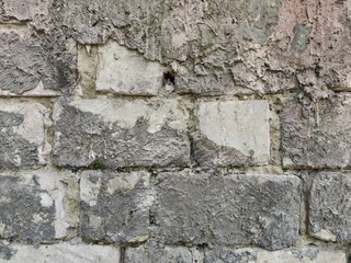 Rectangular brick wall. Between the stones gray cement