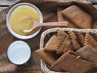 The view from the top.Background about healthy natural dessert. Diet cookies made from rye flour, a glass of milk and honey on an ancient wooden table.