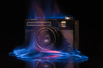 The camera burns with fire on a black background