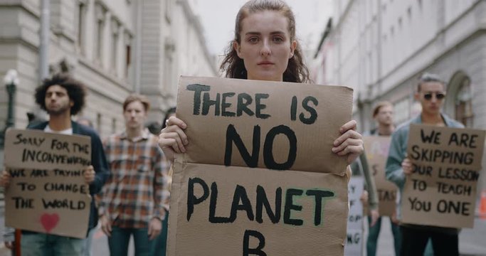 Group of protestors on the streets with posters. Activists protesting against pollution and global warming.
