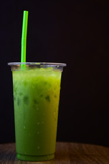 matcha green tea latte in takeaway cup on Black background