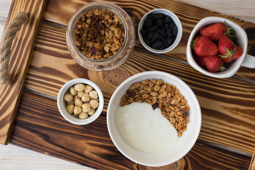 Plate with muesli, nuts and strawberries, healthy breakfast