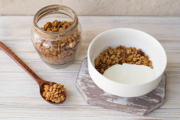 Dry breakfast, oat with nuts, yogurt and strawberries on a wooden table