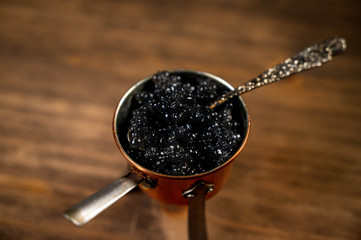 Top view of black caviar on a wooden background. Food background.