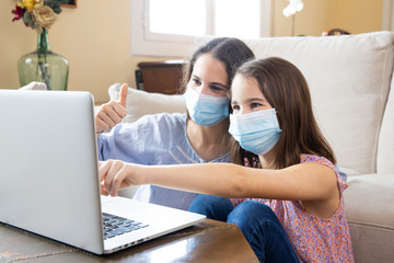 Two sisters making a video call with face mask