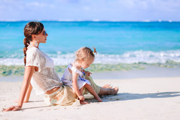Beautiful mother and daughter on the beach enjoying summer vacation.