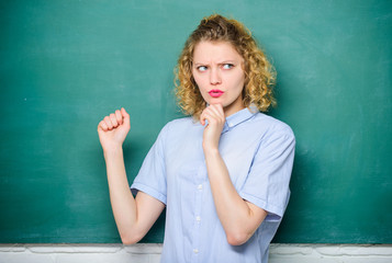 she ponders over the answer. woman teacher at school lesson. education. Students life. back to school. woman likes studying. knowledge day. empty blackboard information. student at blackboard