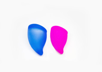 Two colorful, pink and blue sizes of menstural cups from medical high quality silicone, 20 and 30 ml capacity, for safe menstual female period, ecological, zero waste device at isolated background