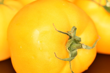 Ripe juicy yellow tomato on a black background.