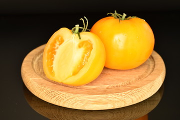 Ripe juicy yellow tomato on a black background.