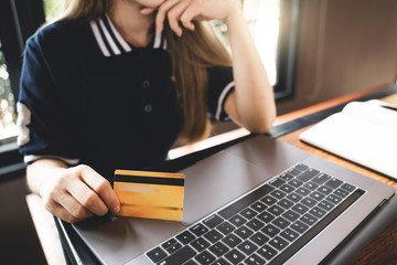 Close up female hands holding smart phone and credit card for online shopping.