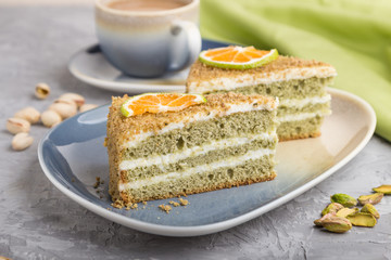 Homemade cake with milk cream and pistachio with cup of coffee on a gray concrete background. side view, selective focus.