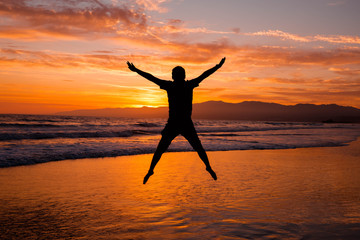 Fototapeta premium Silhouette of a young man jumping up. Concept of successful business