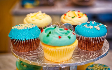 Cupcakes on the round stand at bakery storefront reflex