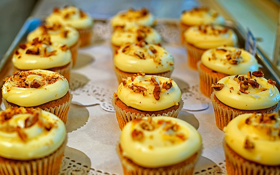 Creamy cupcakes with nuts on the storefront reflex