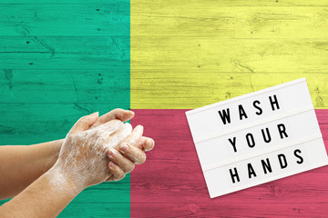 Benin flag background on wooden surface. Minimal wash your hands board with minimal international...